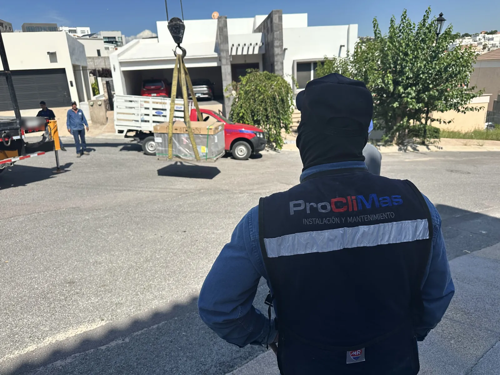Técnico de MYR Proclimas supervisando la maniobra con grúa de un equipo de aire acondicionado en Chihuahua